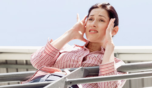 Woman holding head and looks nauseous